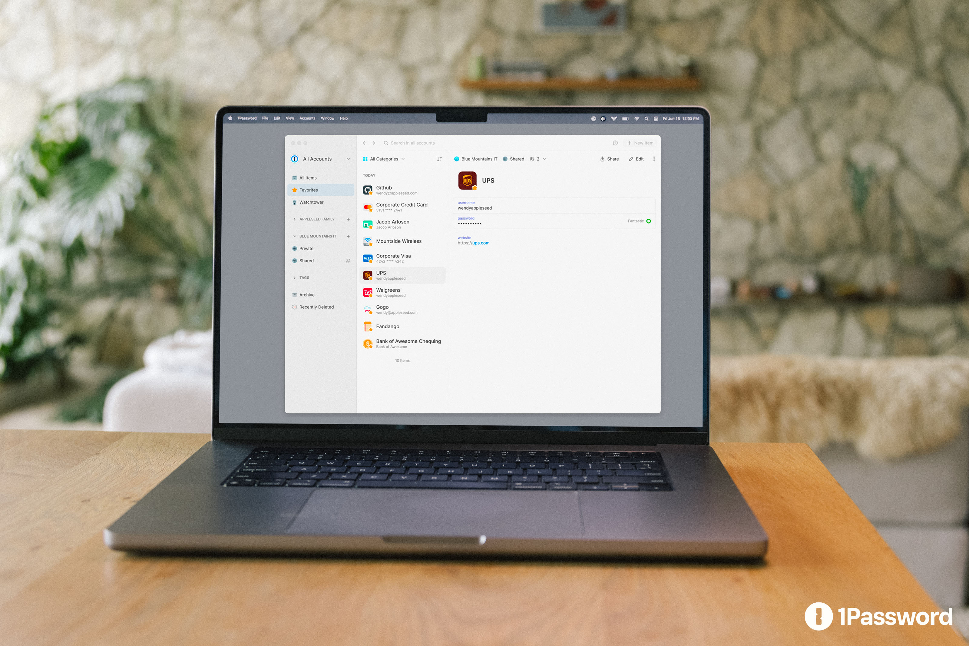 A laptop displaying the standard 1Password app on a table. Official media-kit photograph, not the Agents approval interface.